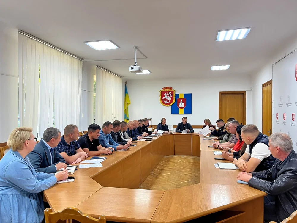Нарада в залі громади з гербами Володимира та прапором України