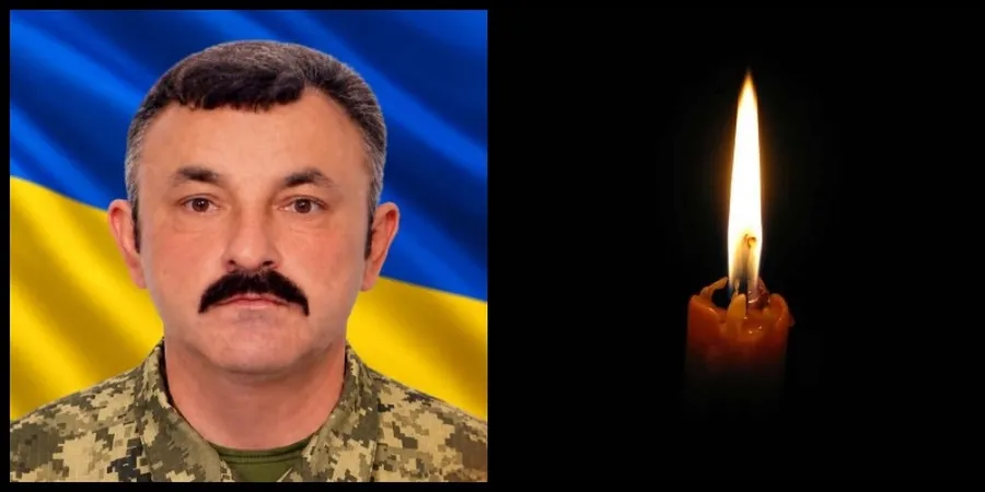 Портрет військового на тлі прапора України та запалена свічка