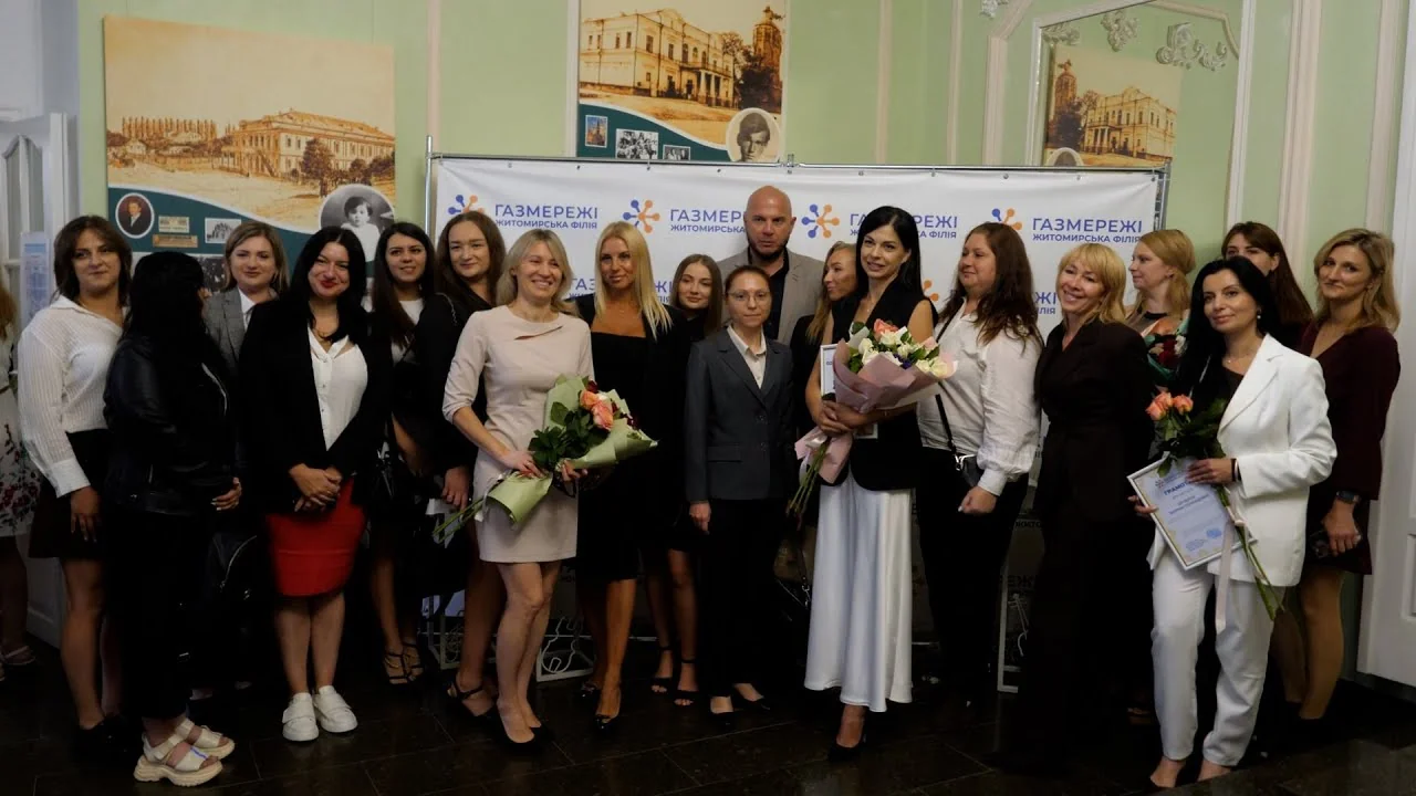 Колектив філії Газмережі з букетами квітів біля корпоративного банера